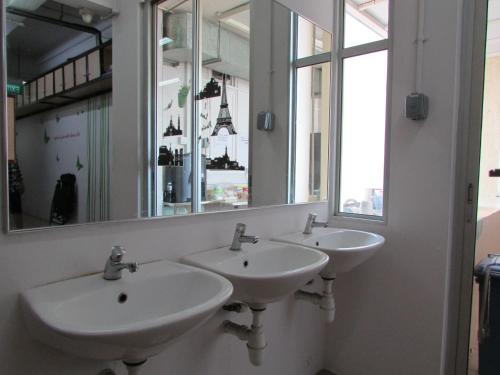 新加坡梅多斯胶囊旅馆的带大镜子的浴室内的三个盥洗盆