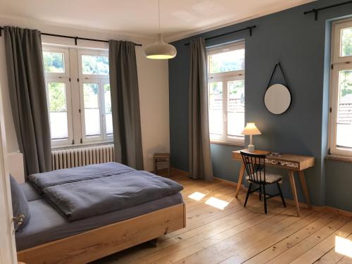 特里贝格Stilvolle Ferienwohnung im Herzen von Triberg的卧室配有一张床、一张书桌和窗户。