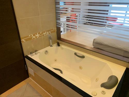 台北HATAGO+ THE ALLEY的带浴缸的浴室和窗户