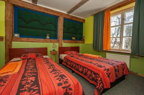 Pilsrundāle巴尔塔玛雅酒店的绿墙客房内的两张床