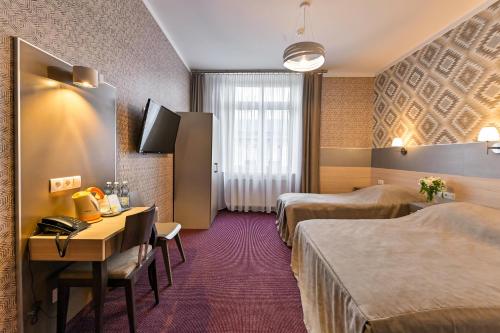 克拉科夫卡齐米日酒店的酒店客房配有两张床和一张书桌