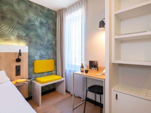 滑铁卢宜必思布鲁塞尔滑铁卢酒店的客房设有一张床和一张带黄椅的书桌