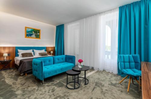 法扎纳Brijuni Hotel Neptun的酒店客房带蓝色的床和蓝色的椅子