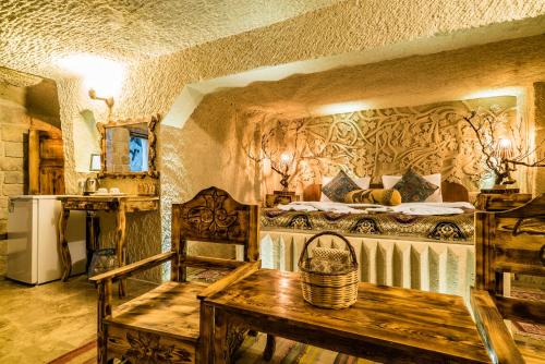 内夫谢希尔Cappadocia Ennar Cave Swimming Pool Hot & SPA的卧室配有一张床和一张桌子