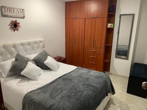 富萨加苏加Hermoso apartamento con parqueadero的一间卧室配有一张大床和一个木制橱柜
