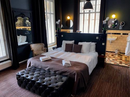 海尔德罗普奈维尔酒店的一间卧室配有一张大床,内有长凳