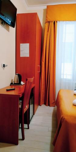 罗马珠穆朗玛峰酒店的一间卧室配有书桌、床和窗户。