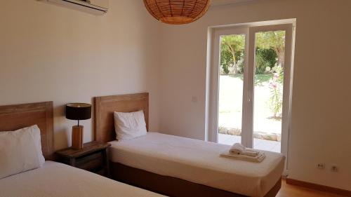 卡巴纳斯·德·塔维拉T2 Cabanas Gardens piscina e praia的一间卧室配有两张带毛巾的床