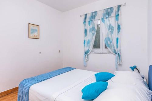 科里米诺Apartment Mira 3的一间卧室配有床和带蓝色枕头的窗户。