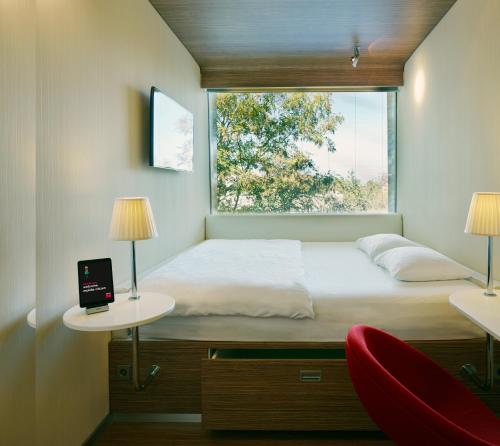 阿姆斯特丹南阿姆斯特丹M公民酒店的一间卧室设有床、两张桌子和一扇窗户
