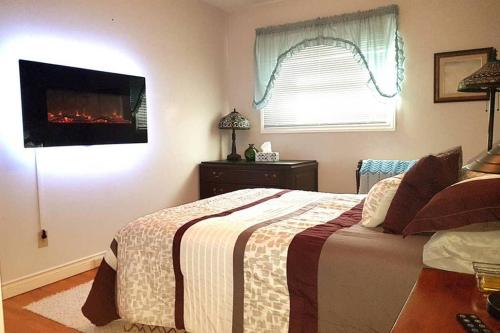 萨尼亚Sarnia Secret - BIG, Private 3 BR/2 BA APT by HWY的卧室配有一张床,墙上配有电视。