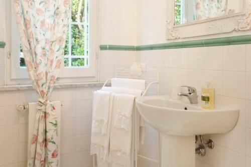 彼得拉桑塔丽莫纳伊亚住宿加早餐旅馆的白色的浴室设有水槽和镜子