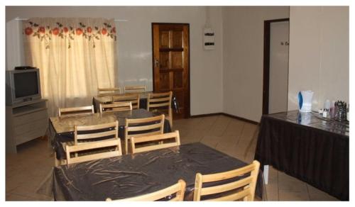 LephalaleAbuelita Guesthouse - Room 1的一间带桌椅和电视的用餐室