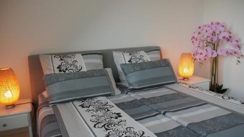 希尔德斯海姆Stadtnahe Komfortferienwohnung für Familien und Geschäftsreisende的一间卧室配有一张带两盏灯和鲜花的床。