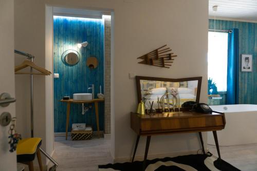 安旱斯达塞拉Casa da Almoinha的带浴缸的浴室以及带蓝色墙壁的卧室