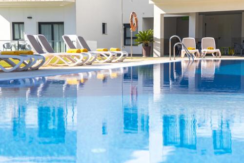 奇克拉纳－德拉弗龙特拉康普乐约阿苏尔公寓的一个带躺椅的游泳池和一间酒店