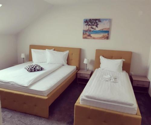 托普利察Pensiunea La Gagea的一间卧室配有两张带白色床单的床