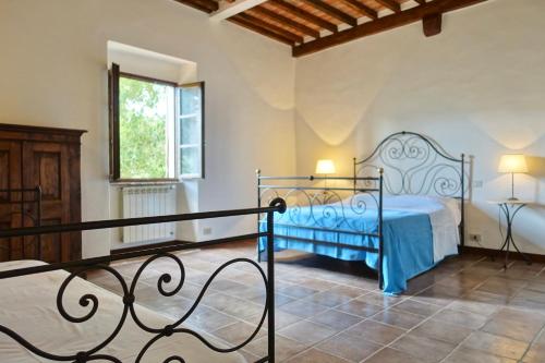 巴尼奥维尼奥尼Casa alla Vecchia Posta di Bagno Vignoni的一间卧室设有蓝色的床和窗户。