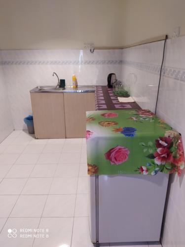 邦咯Pangkor fun fun fun apartment的厨房配有带鲜花的冰箱