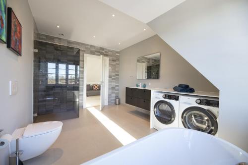 奥尔堡aday - 3 bedroom - Modern Living Apartment - Aalborg Center的房屋内的浴室设有洗衣机和烘干机