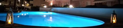 利多迪耶索罗B&C Apartments LA POSTA Home的大楼内的大型游泳池配有蓝色灯光