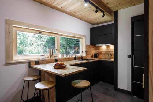 扎科帕内Mount Apart Sport House的厨房配有带凳子的柜台和窗户。