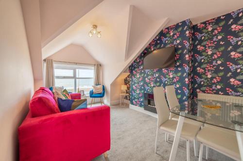 克利夫利斯Charles Alexander Short Stay - Highcliffe Apartments的客厅配有红色的沙发和桌子