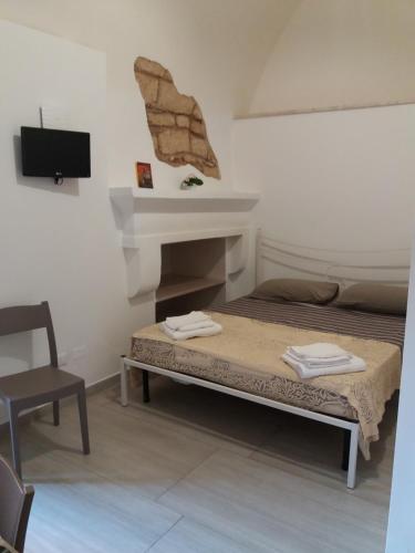 乌真托TORRE SUL MARE affittacamere Ugento的一间小房间,配有一张床和一个壁炉