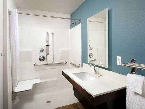 普莱诺WoodSpring Suites Plano - North Dallas的一间带水槽和淋浴的浴室