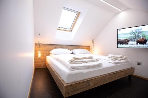 马里博尔Becycle Sustainable stay and travel的一间卧室配有一张带白色床单的床和一扇窗户。