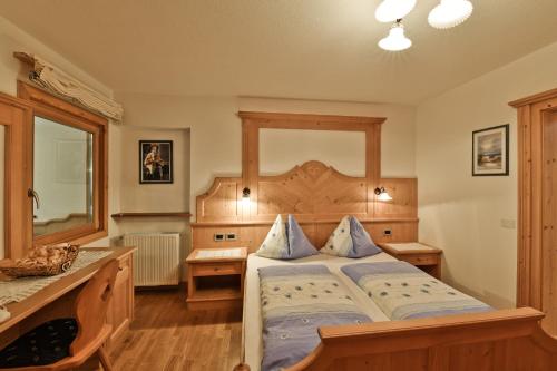 拉瓦莱西萨米里奥公寓的一间卧室配有一张大床和木制床头板