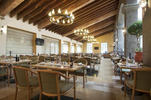 托卢卡托卢卡特罗肯嘉年华酒店 的餐厅设有木制天花板和桌椅