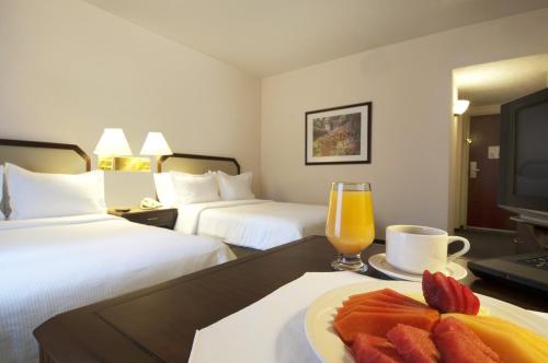 托卢卡托卢卡特罗肯嘉年华酒店 的一间酒店客房,内配一盘水果和一杯橙汁