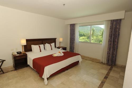 伊斯塔帕Gamma Plaza Ixtapa的一间卧室设有一张大床和大窗户