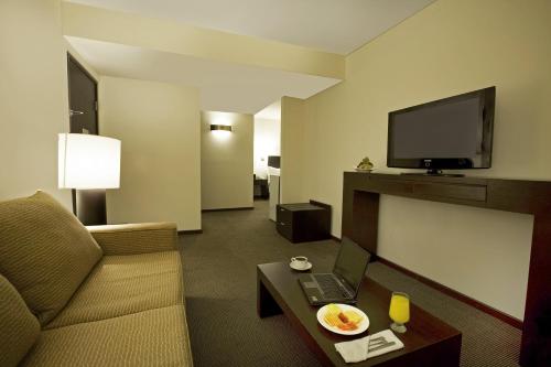 特皮克特皮克节日酒店的酒店客房设有沙发、电视和桌子。