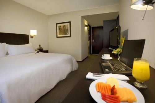 特皮克特皮克节日酒店的酒店客房设有一张床、一台笔记本电脑和一盘食物