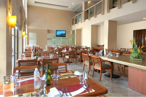 伊达尔戈州波萨里卡波萨里卡嘉年华酒店的用餐室配有木桌和椅子