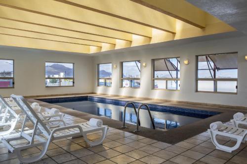 华雷斯城华雷斯城费斯塔酒店的一个带白色椅子的游泳池和一个游泳池