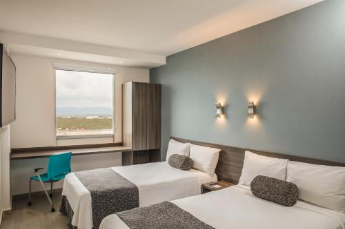 蒙特雷一号蒙特雷机场酒店的酒店客房设有两张床和窗户。
