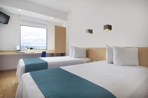 托卢卡托卢卡机场酒店的酒店客房设有两张床和窗户。