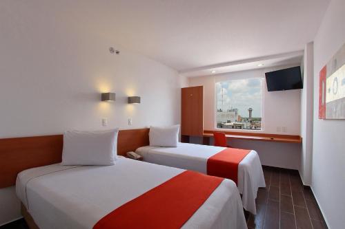 比亚埃尔莫萨比亚埃尔莫萨中心One酒店的酒店客房设有两张床和窗户。