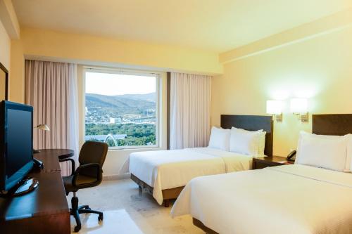 图斯特拉古铁雷斯图斯特拉 - 古铁雷斯费斯塔客栈酒店的酒店客房设有两张床和窗户。