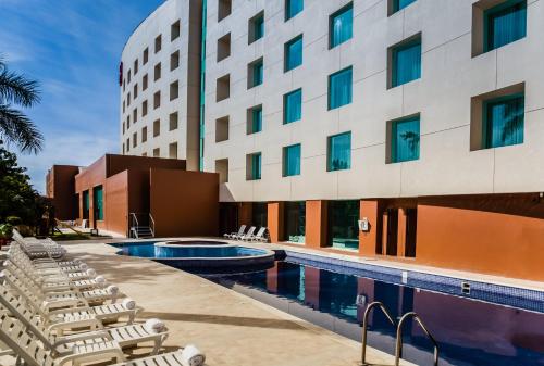 库利亚坎库利亚坎嘉年华酒店的酒店游泳池旁设有躺椅