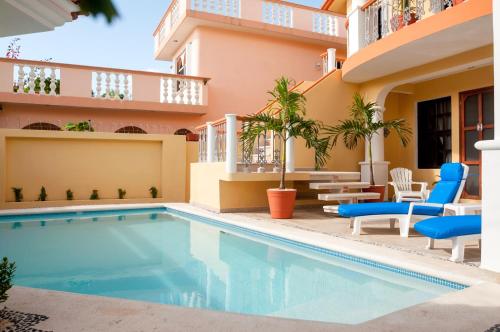 莫雷洛斯港里盖托度假公寓酒店的一座带椅子的建筑和酒店前的游泳池
