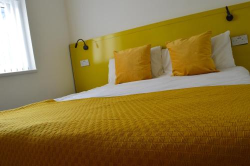 莱斯特Bell Gate House的一间卧室配有一张带黄色枕头的大床