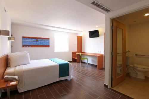 比亚埃尔莫萨比亚埃尔莫萨中心One酒店的一间卧室配有一张床,浴室设有卫生间