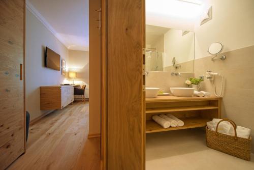 弗拉绍蒙特纳洛阿尔卑斯美食酒店的一间带水槽和镜子的浴室