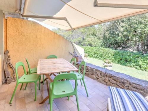 蓬塔阿拉Belvilla by OYO Le Mimose nr 12的庭院配有木桌和绿色椅子