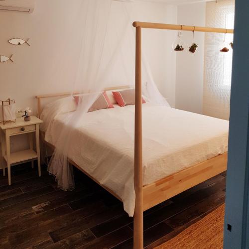 兰卡Ideal parelles aptm amb encant estil Mediterrani i tranquil a Llançà的一间卧室配有带白色床单和粉红色枕头的床。