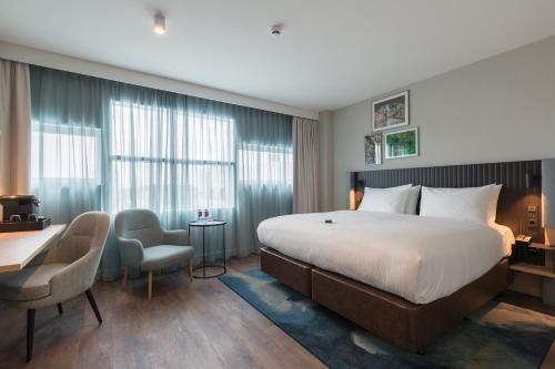 乌得勒支Crowne Plaza Utrecht - Central Station, an IHG Hotel的酒店客房,配有一张床、一张桌子和椅子